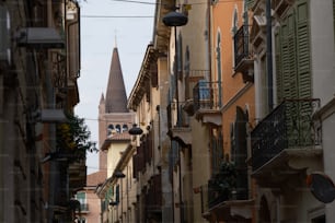 Una stretta strada cittadina con un campanile della chiesa sullo sfondo