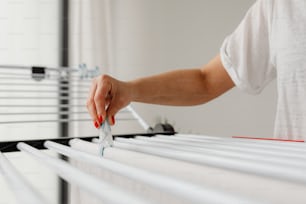 a person is holding a pair of scissors over a row of white drawers