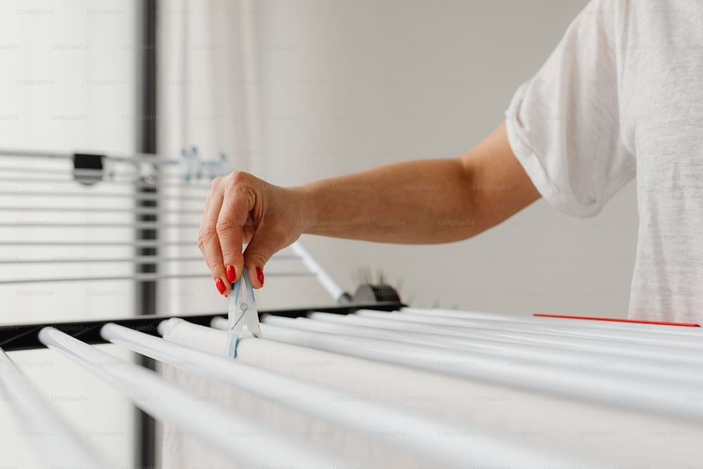 a person is holding a pair of scissors over a row of white drawers