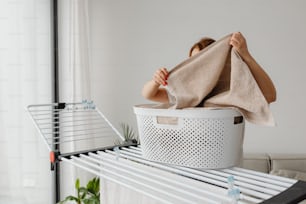 a woman is drying her clothes in a laundry basket