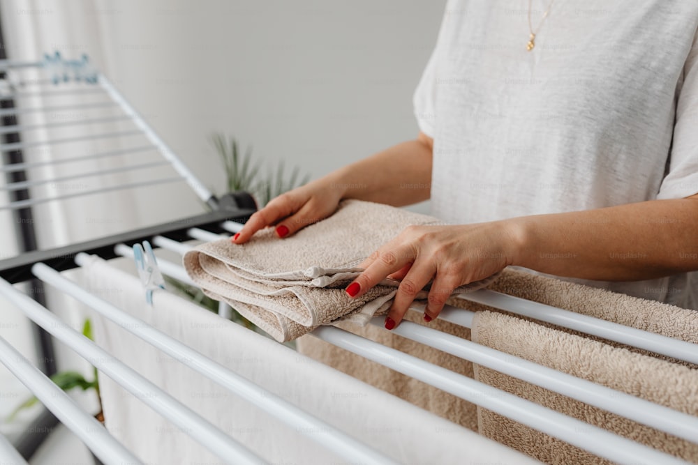 a woman holding a towel on top of a radiator