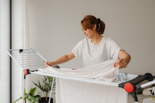 a woman ironing clothes on an ironing board