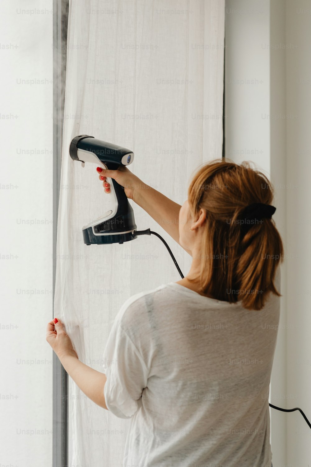 une femme utilisant un sèche-cheveux pour se sécher les cheveux