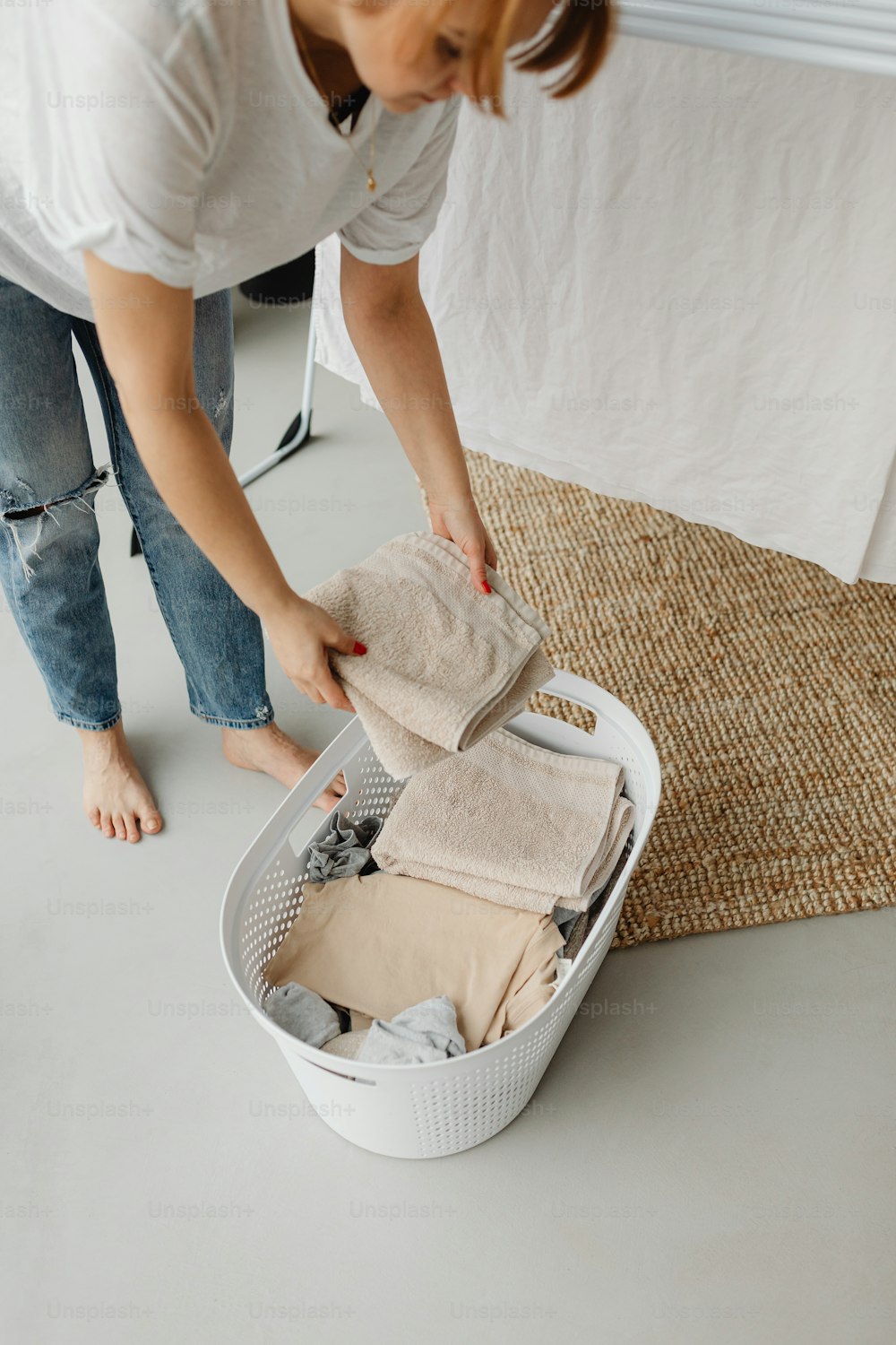a woman unpacking clothes in a basket