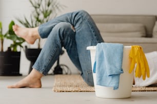 a woman sitting on the floor next to a bucket of cleaning supplies