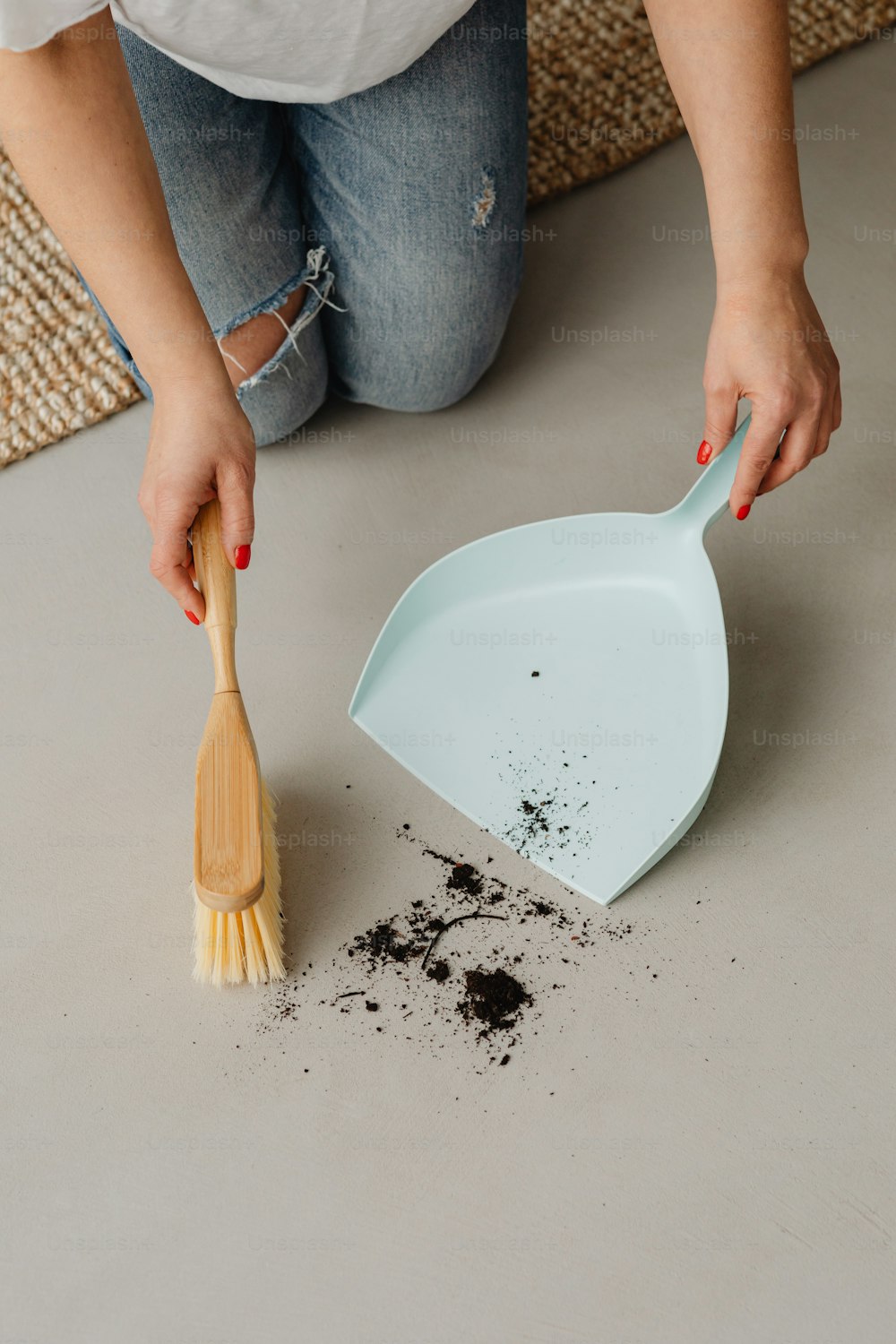 a woman scooping dirt off of a floor with a spatula