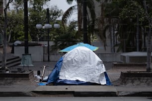 a blue and white tent sitting on the side of a road