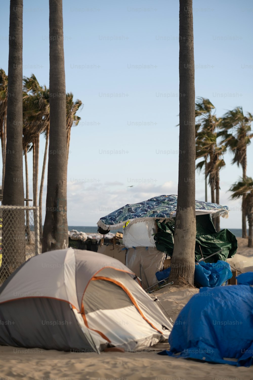 un groupe de tentes assises au sommet d’une plage de sable