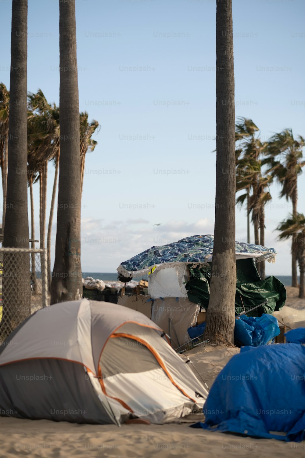 um grupo de tendas sentadas em cima de uma praia de areia