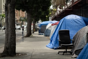 a chair sitting on a sidewalk next to a bunch of tents