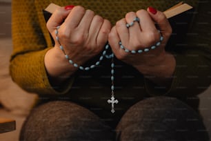 una donna che indossa un rosario e tiene in mano un libro
