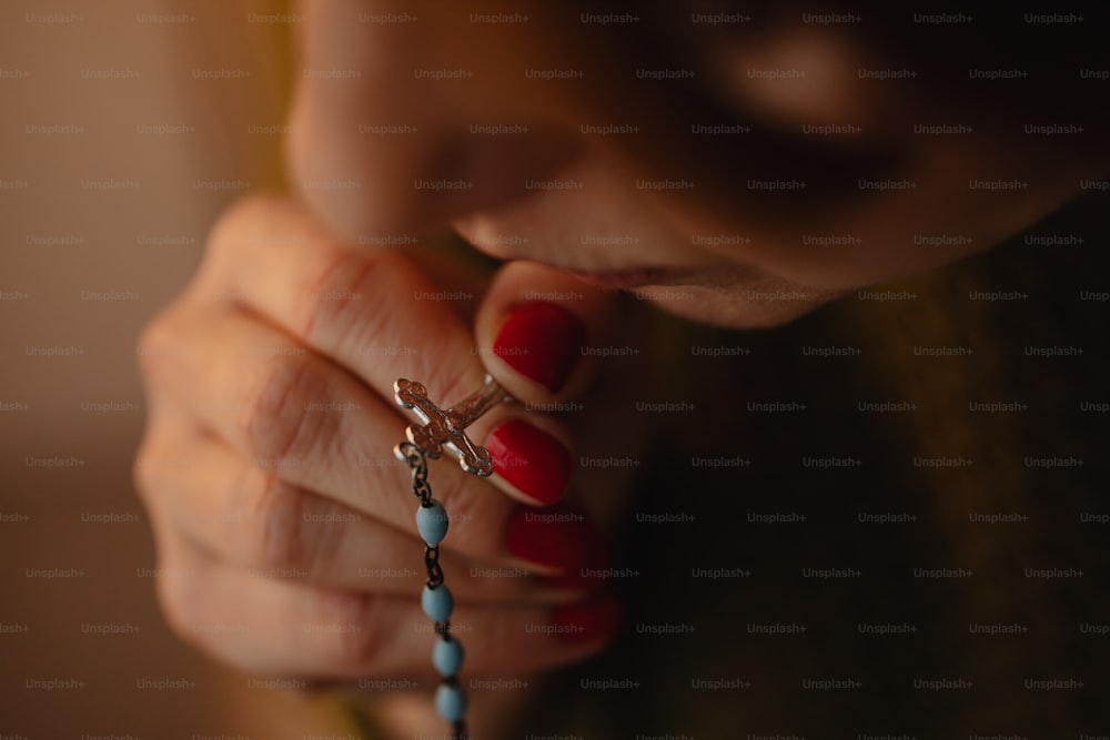 a woman holding a rosary in her hands