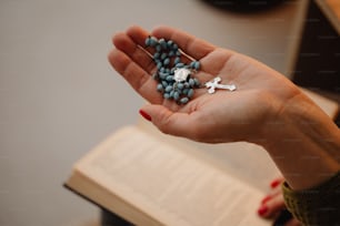 a person holding a rosary in their hand