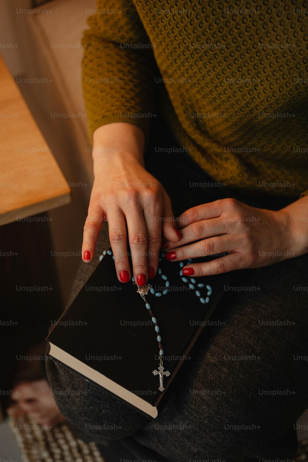 a woman is holding a rosary and a book
