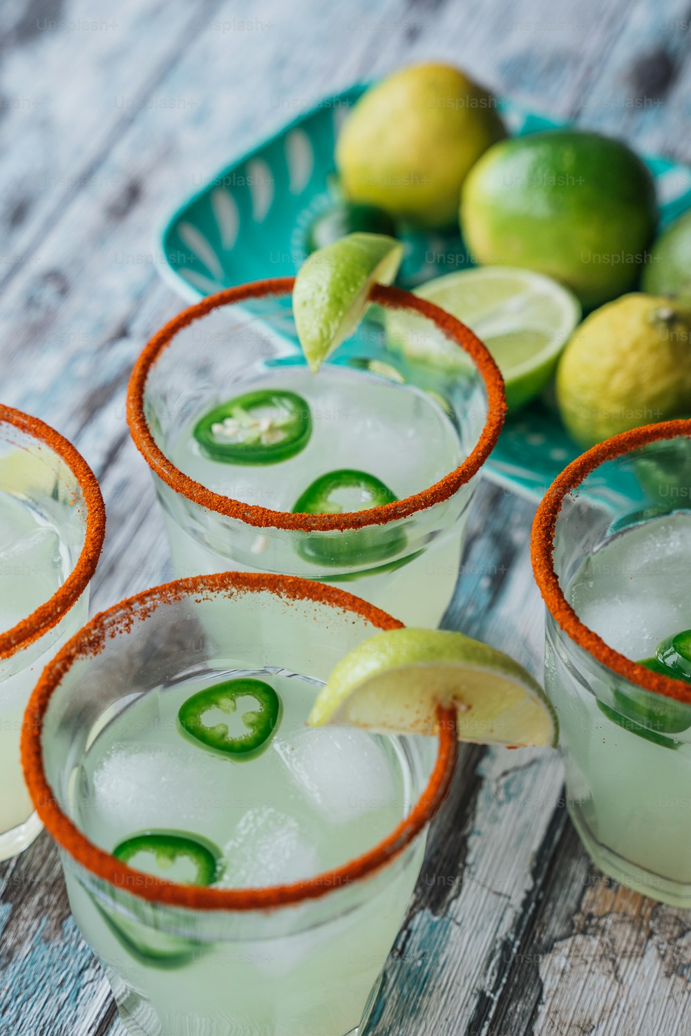 three glasses of limeade with limes and a lime slice