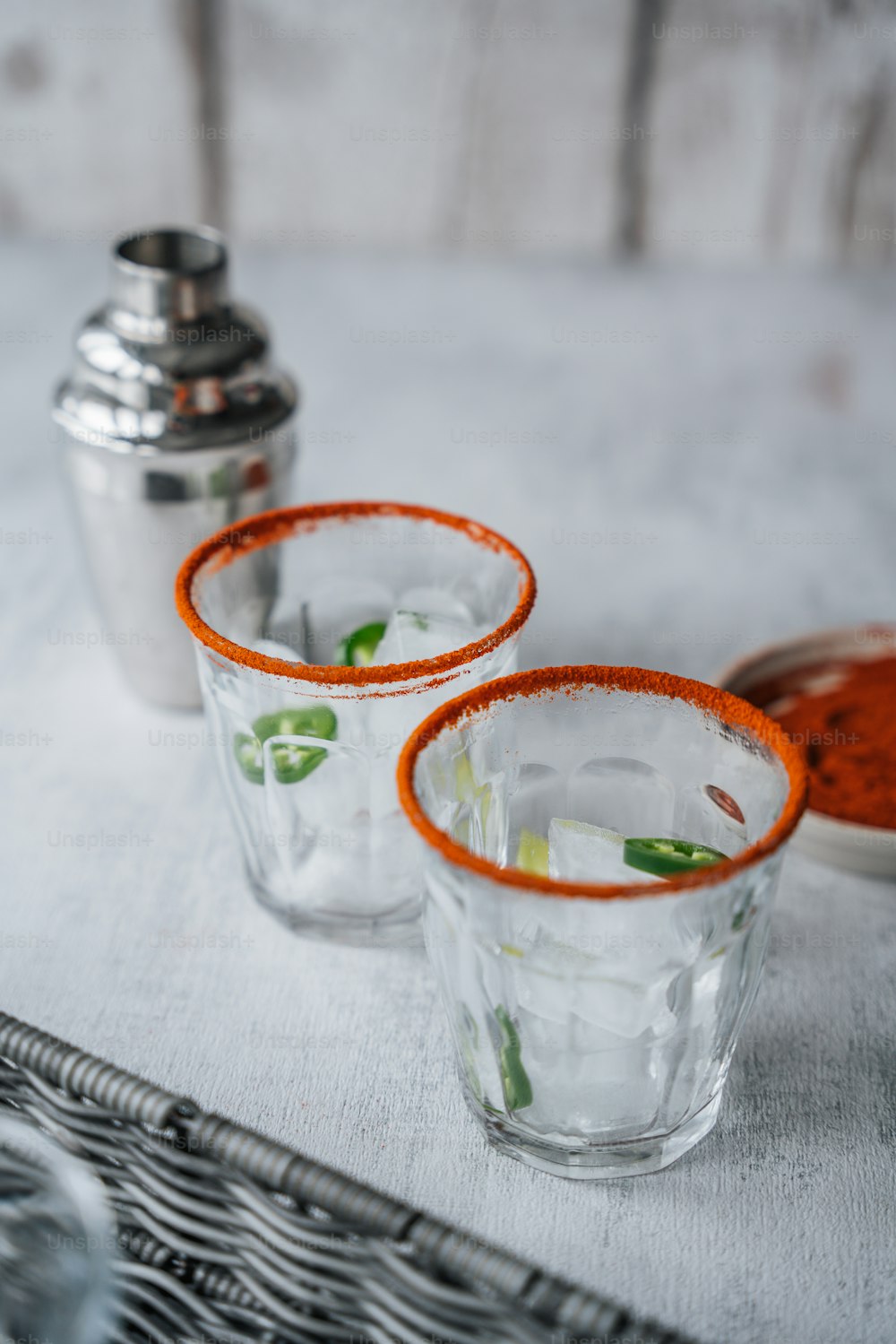 three shot glasses with orange rims on a table