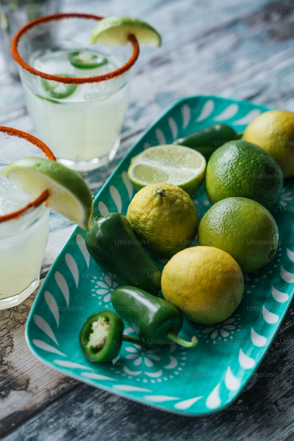 a plate of limes, peppers, and limeade on a table