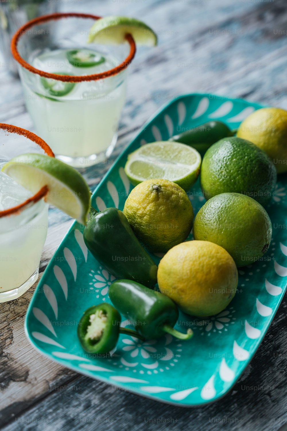a plate of limes, peppers, and limeade on a table