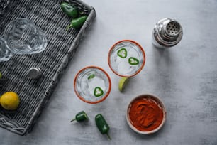 zwei Gläser rote und grüne Chilisauce und ein Salzstreuer