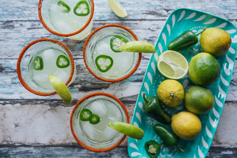 three glasses of limeade with limes and jalapenos