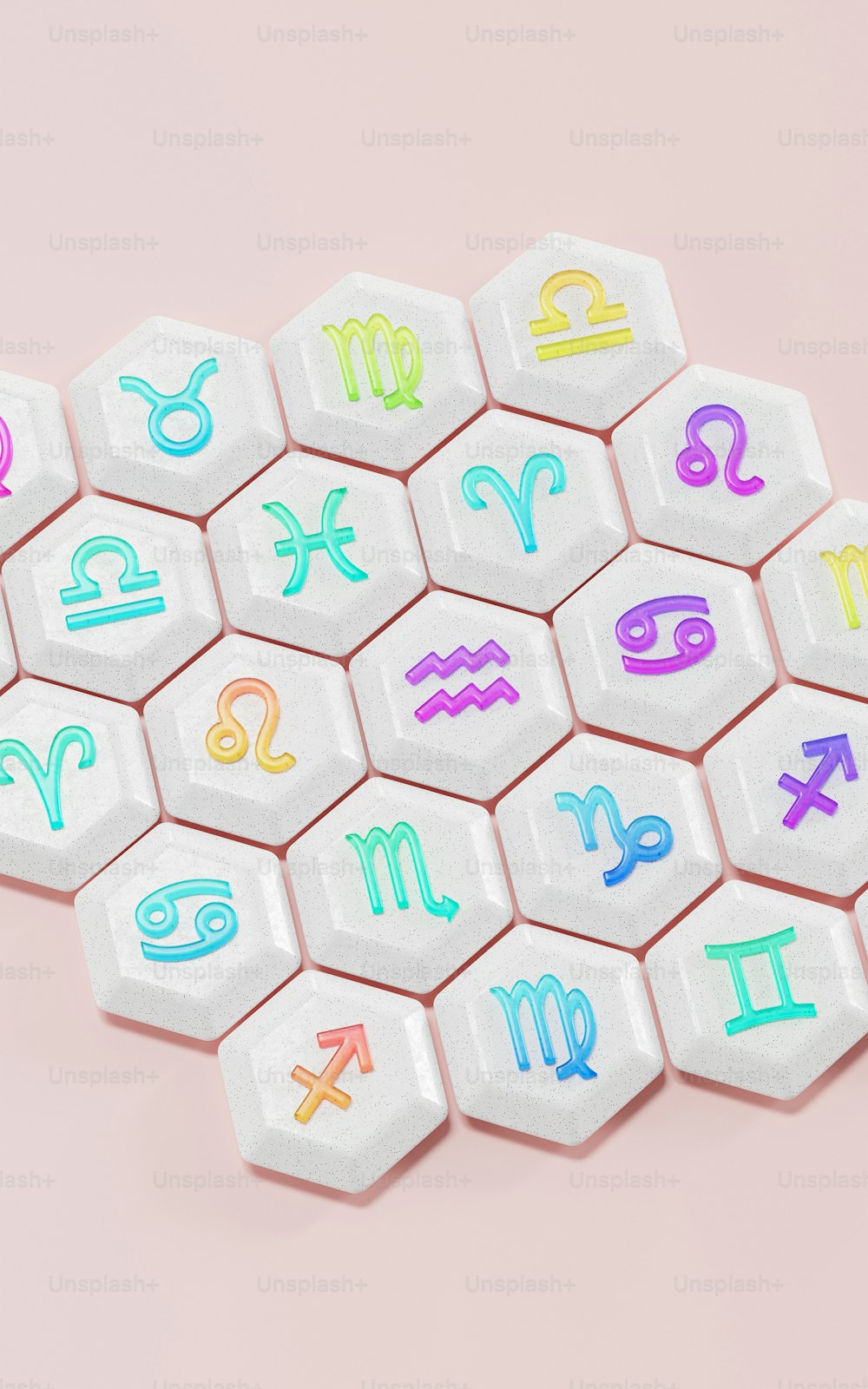 eine Reihe verschiedenfarbiger Astrozeichen auf rosa Hintergrund