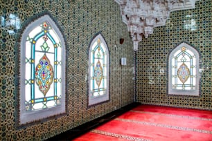 a room with stained glass windows and a red carpet