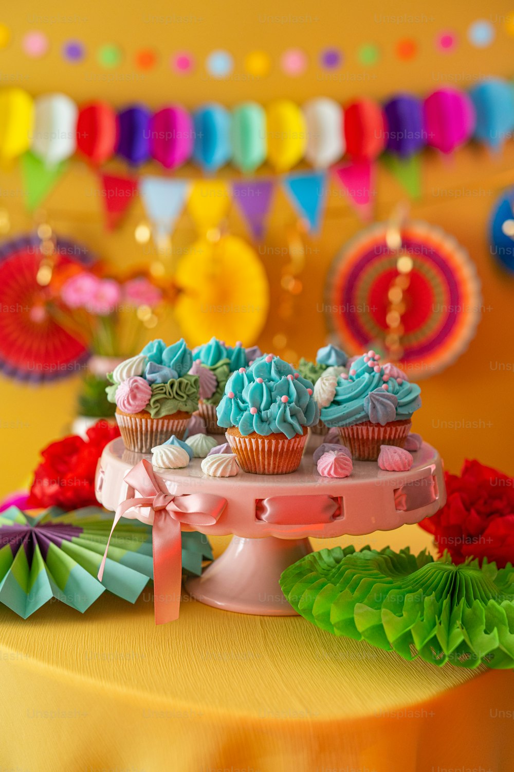 a table topped with a cake and cupcakes
