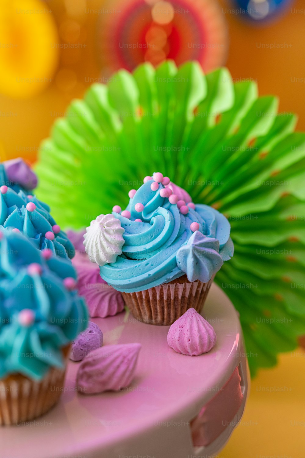 파란색 프로스팅과 분홍색 장식을 곁들인 컵케이크 3개