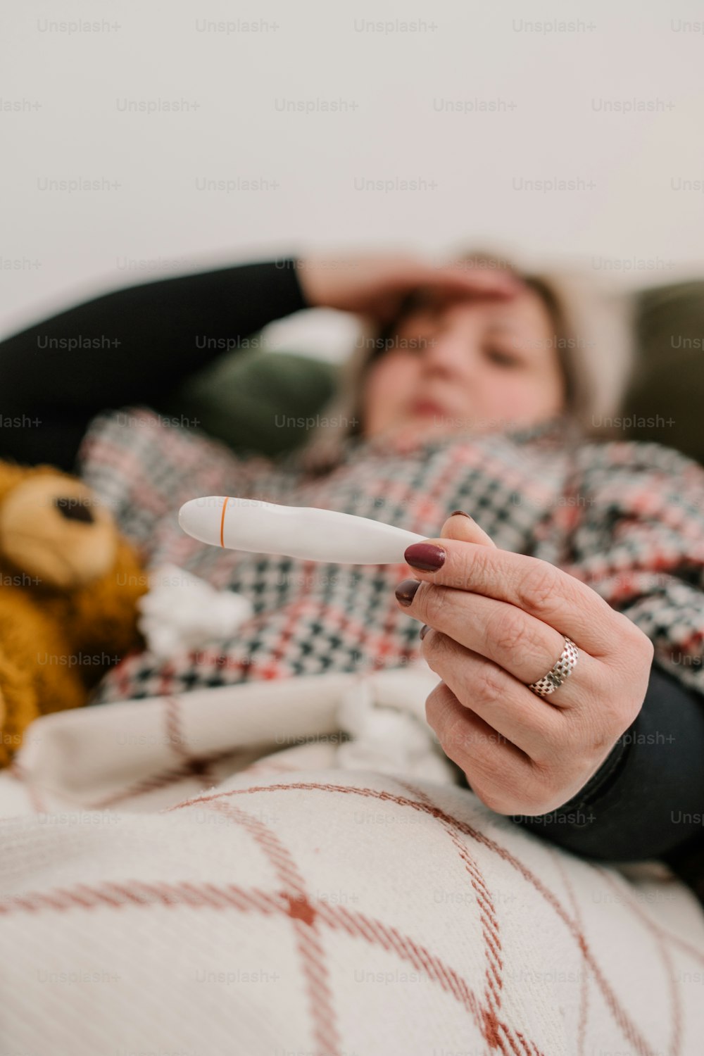 a woman laying in bed holding a remote control