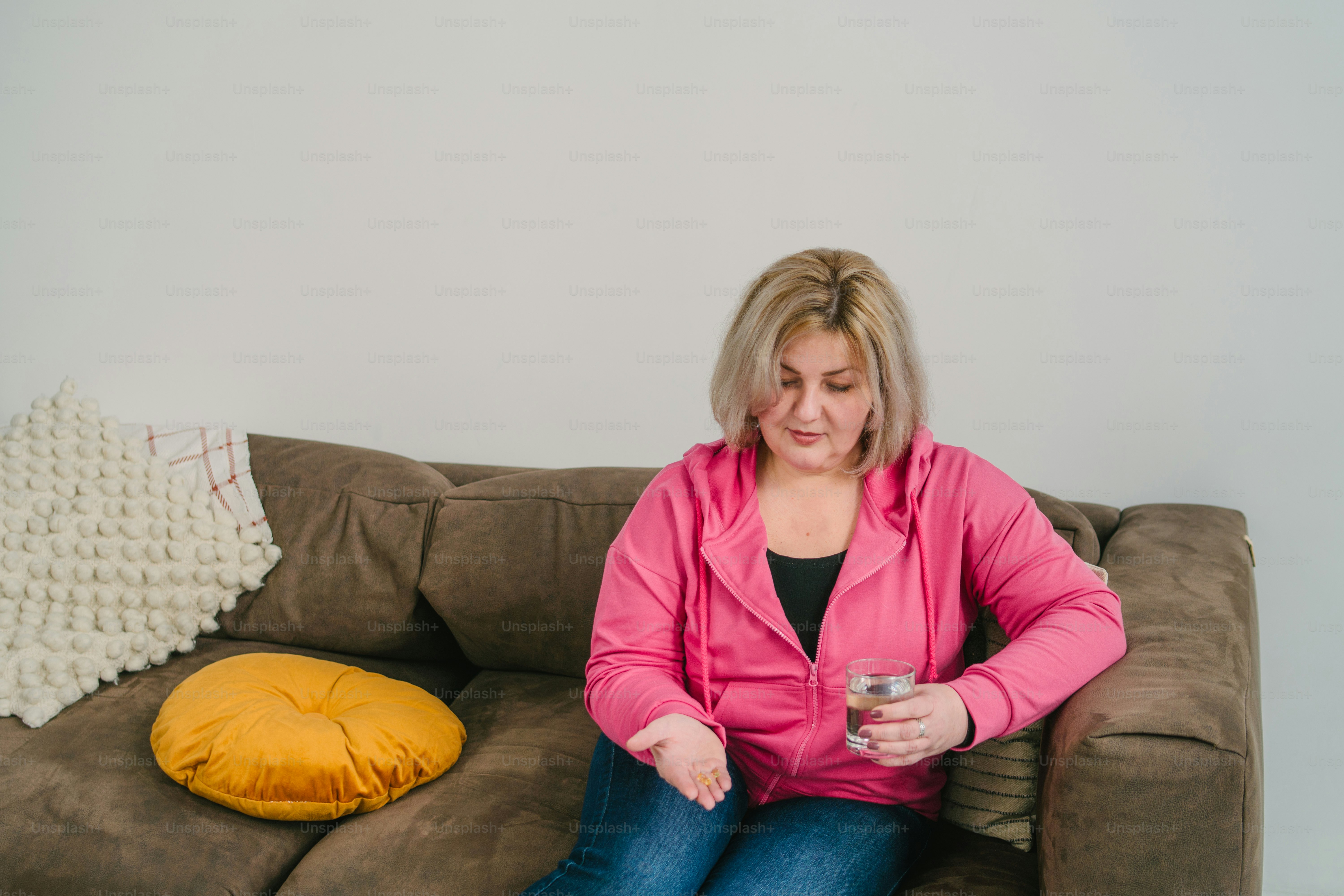 Une femme assise sur un canapé tenant un verre