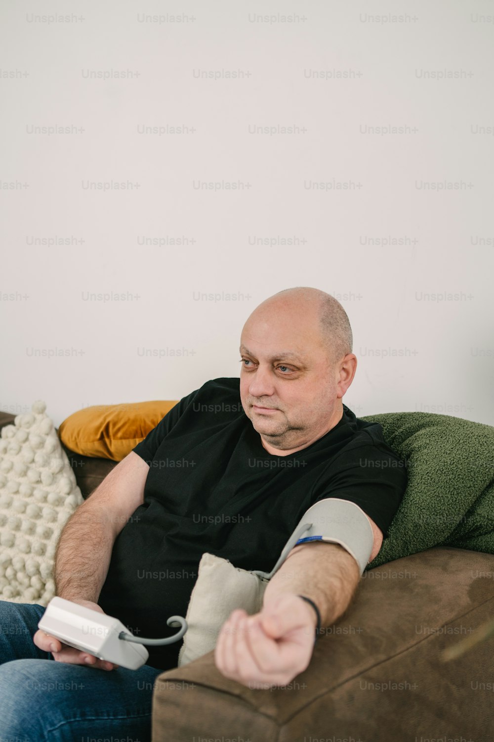 um homem sentado em um sofá segurando um controle remoto