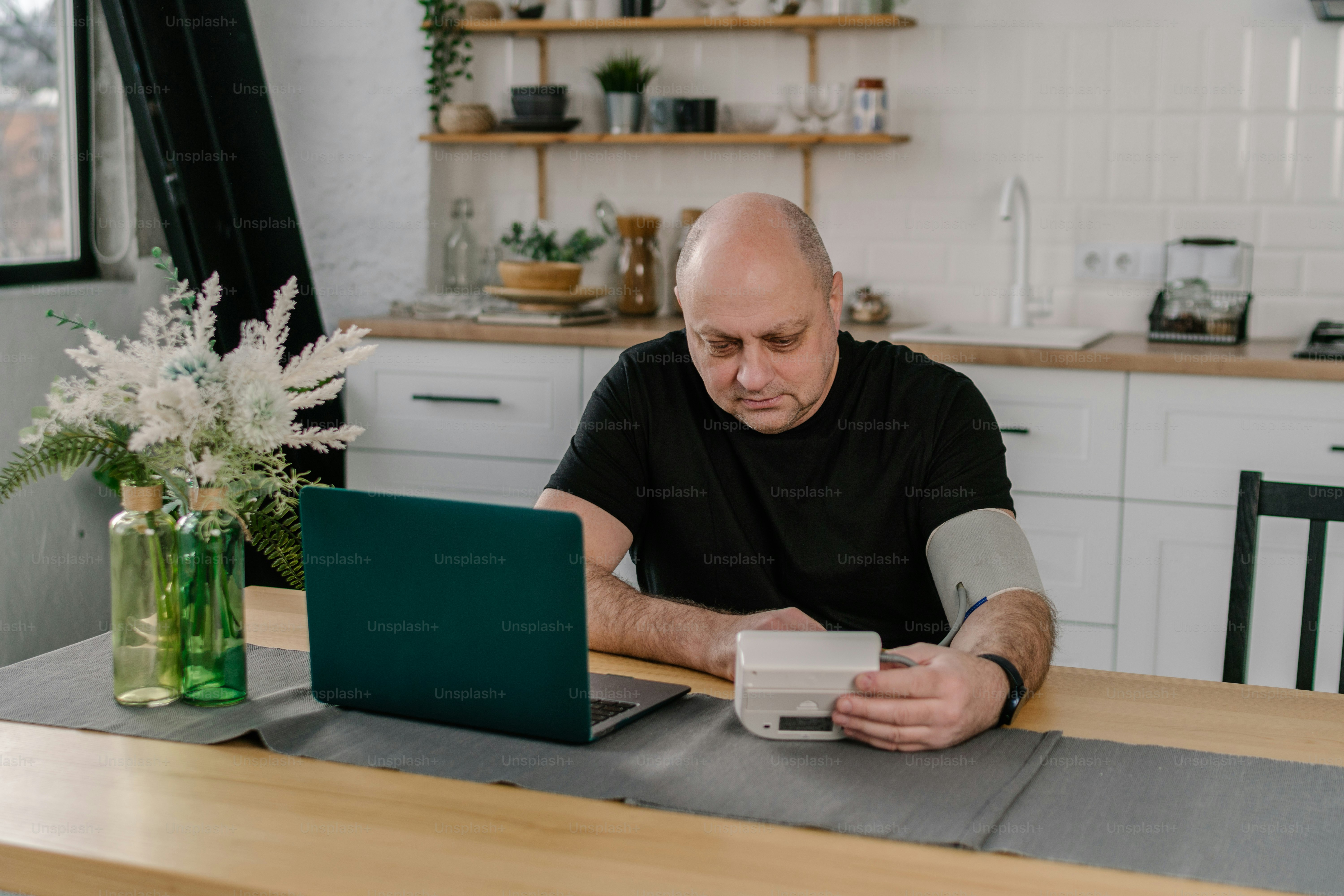 Ein Mann sitzt an einem Tisch und arbeitet an einem Laptop