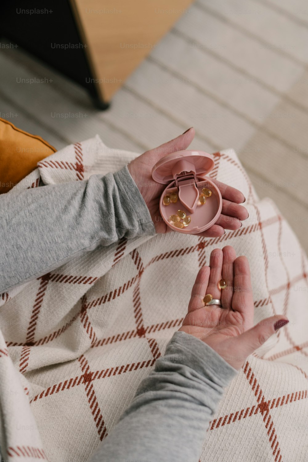 Eine Frau sitzt auf einem Bett und hält einen rosa Ring in der Hand