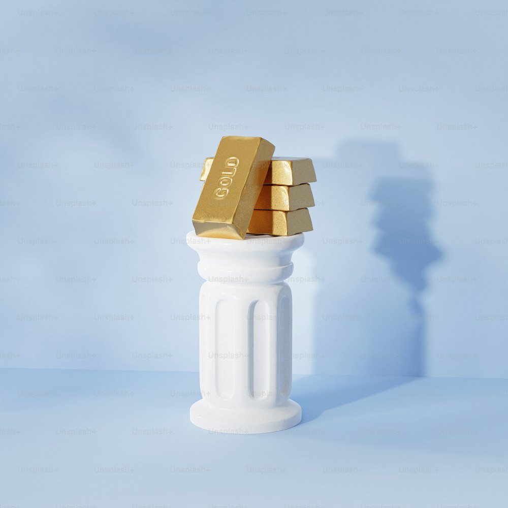 a gold bar sitting on top of a white pillar