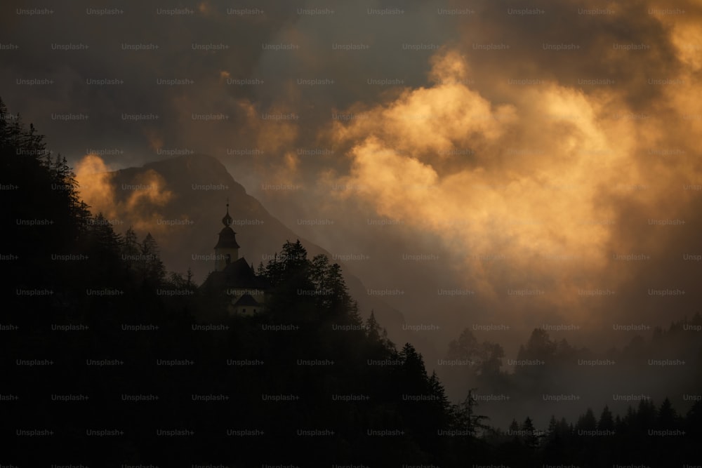 曇り空の下の木々に囲まれた丘の上の教会