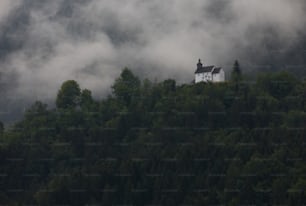 a house on top of a hill surrounded by trees