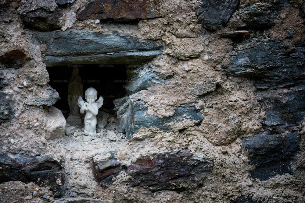 a small statue of an angel in a cave