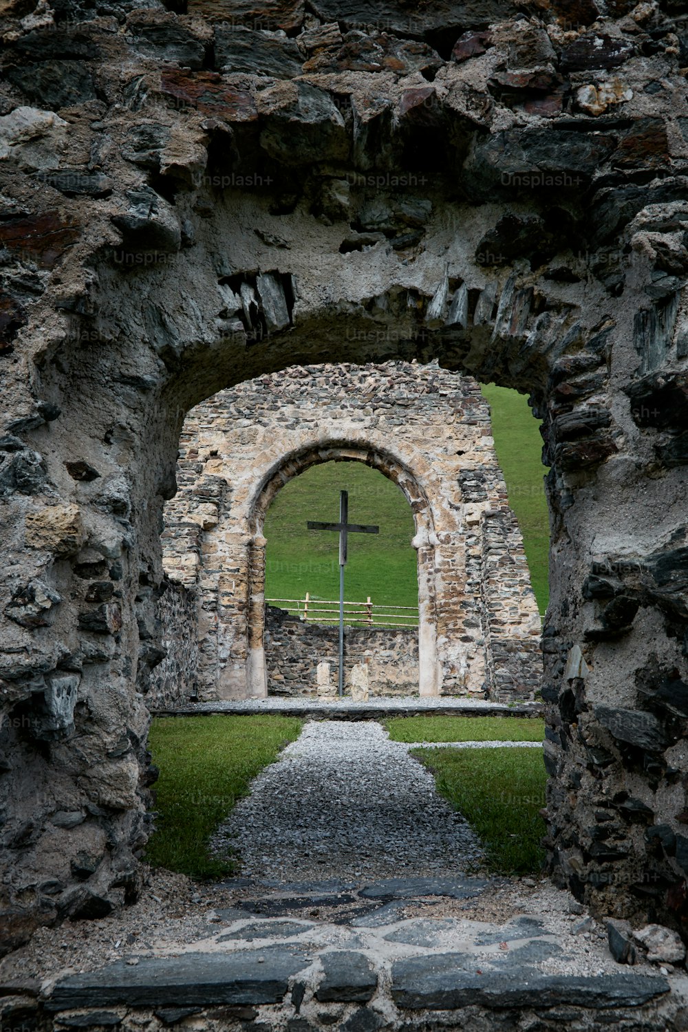 a stone archway with a cross in it