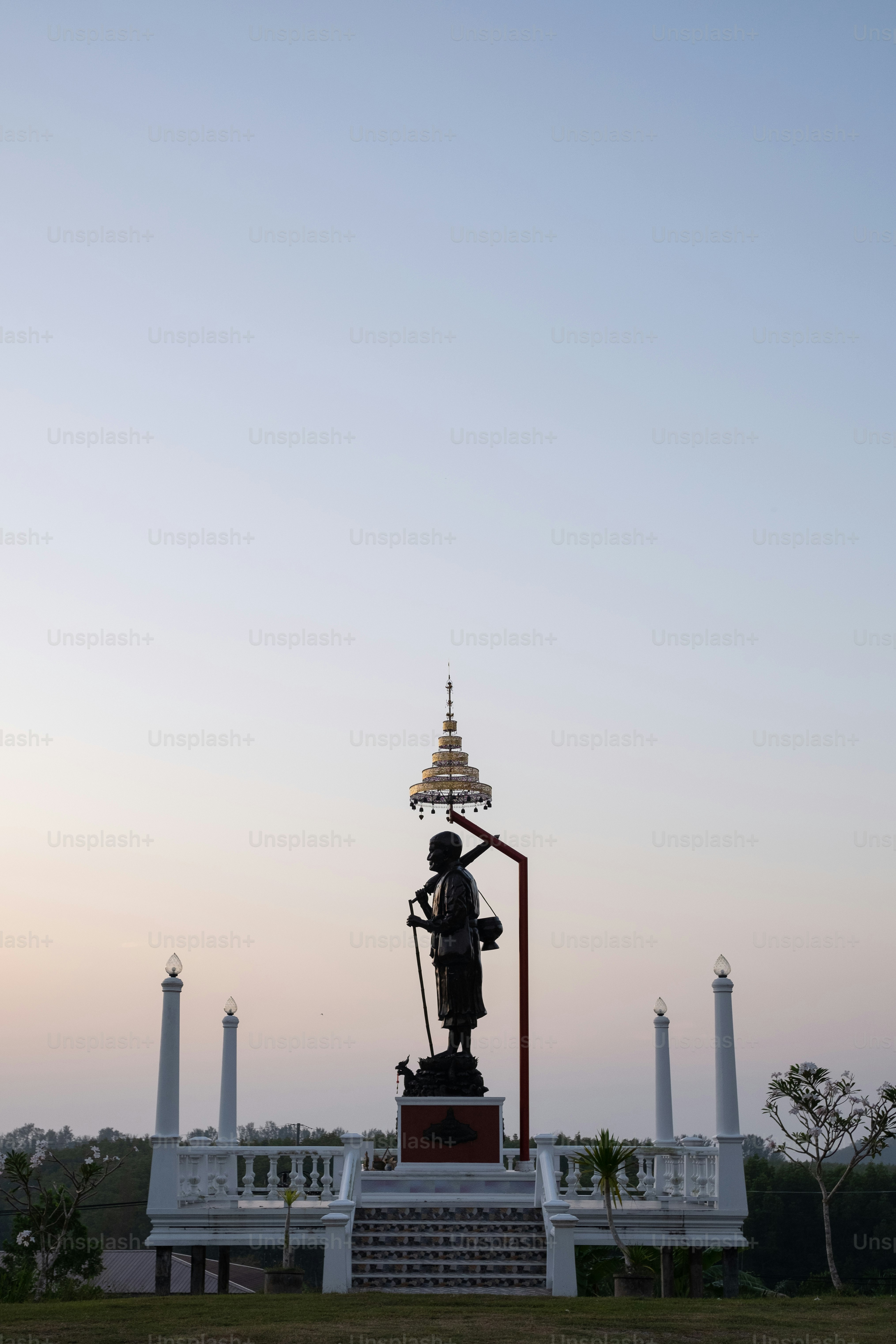 a statue in front of a building with a sky background