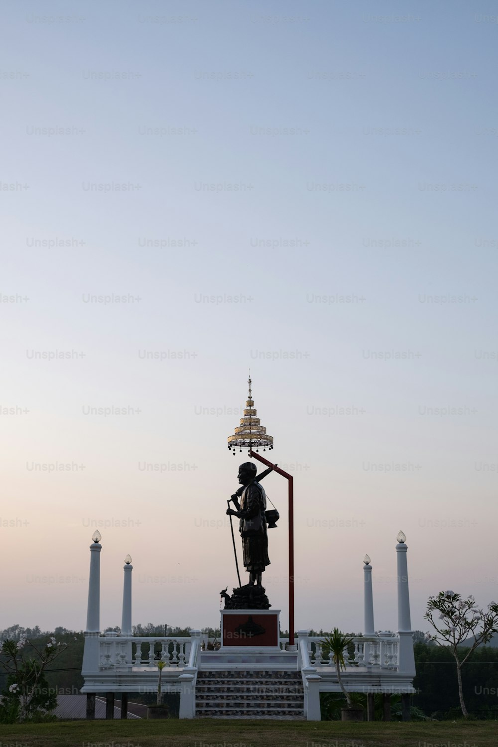 a statue in front of a building with a sky background