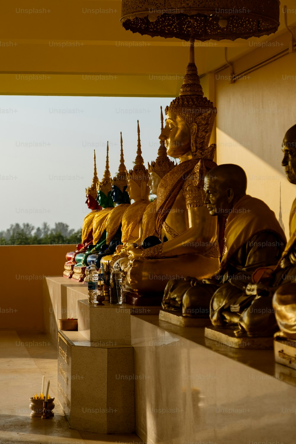 uma fileira de estátuas de Buda sentadas em cima de um balcão
