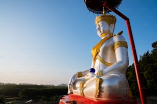 a large white buddha statue sitting on top of a red platform