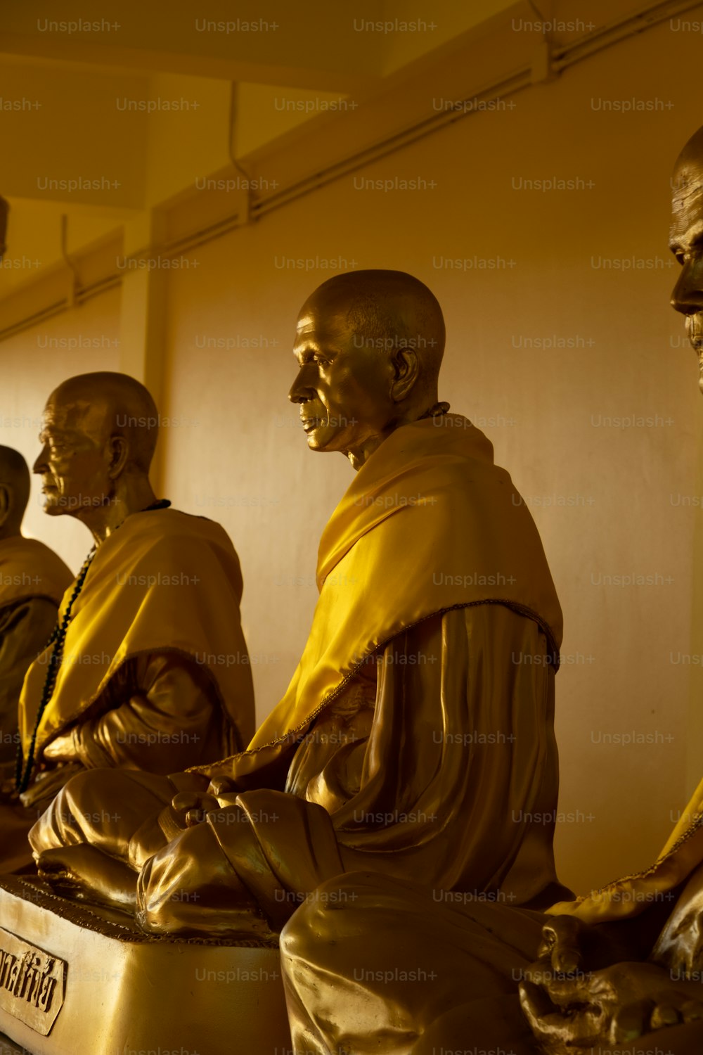 um grupo de estátuas de Buda sentadas uma ao lado da outra