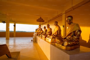a row of buddha statues sitting on top of a wall