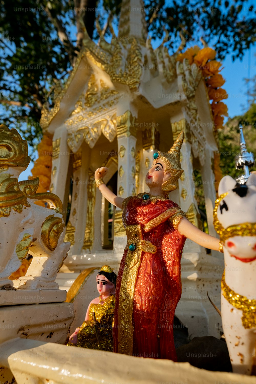 a woman in a red dress standing next to a statue