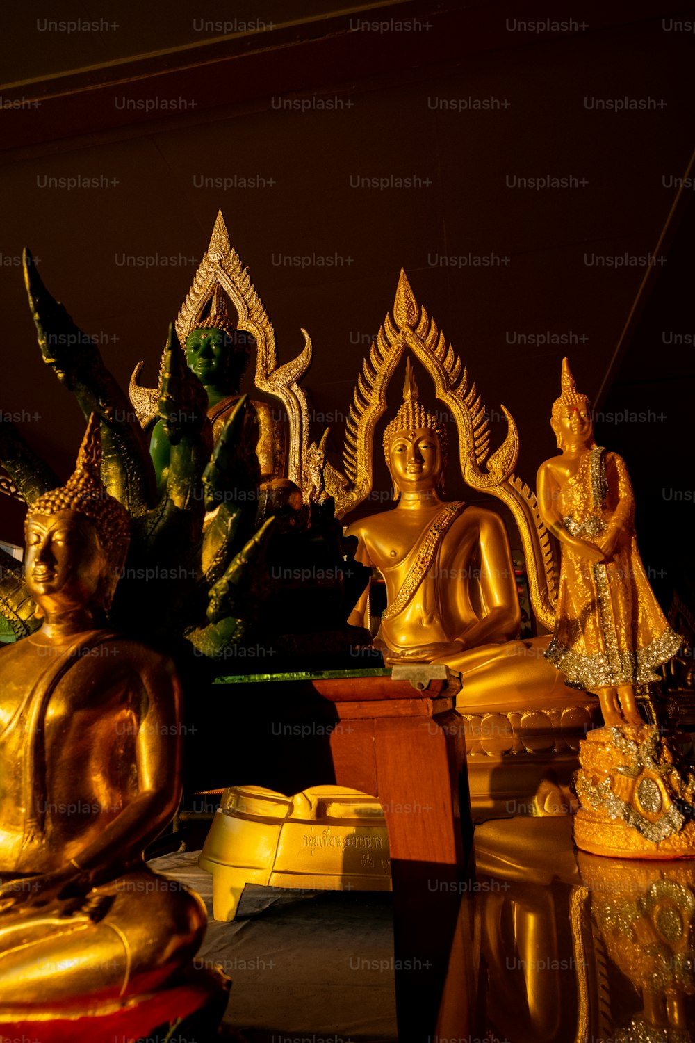 a group of golden buddha statues sitting on top of a table