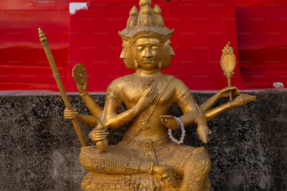 une statue dorée d’une personne tenant un bâton