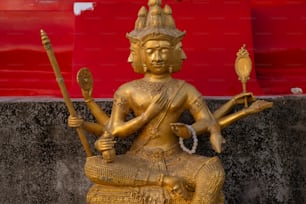 a golden statue of a person holding a staff