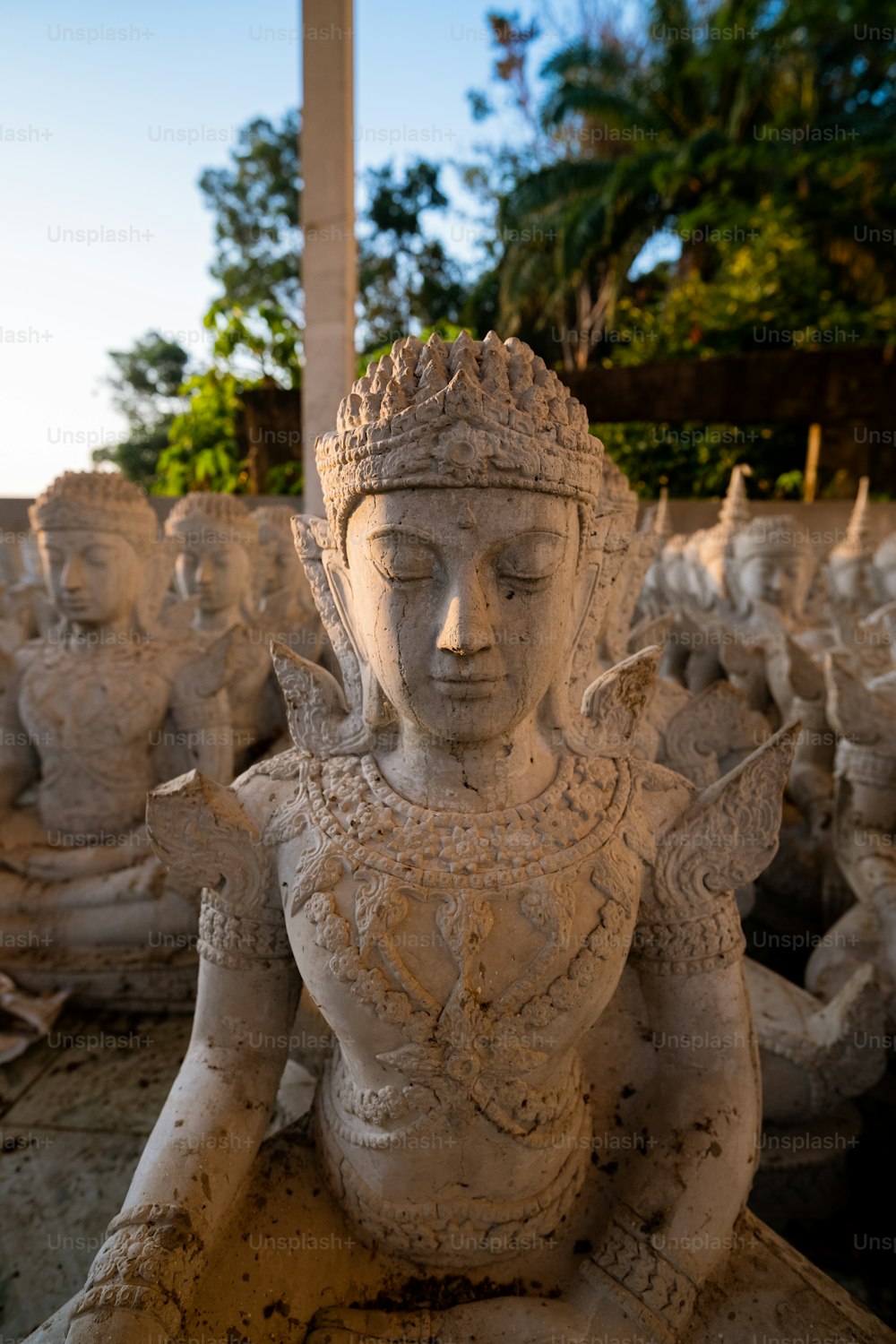 a statue of a woman sitting in a row of other statues