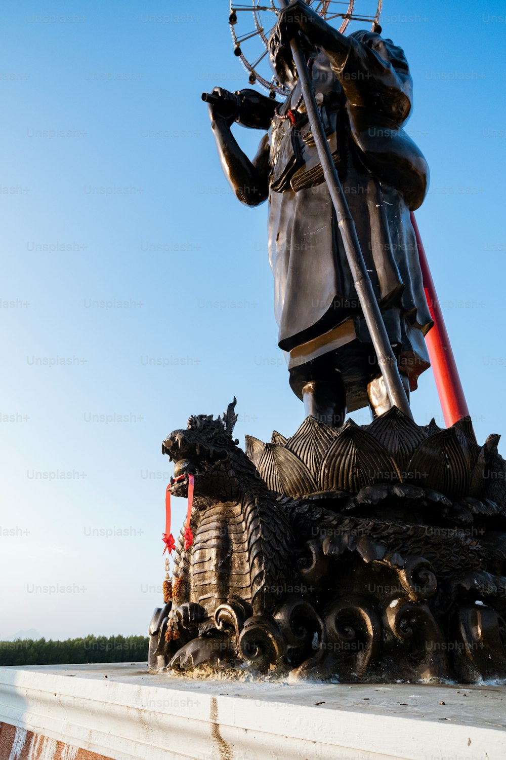 une statue d’un homme avec une épée au sommet d’un bâtiment